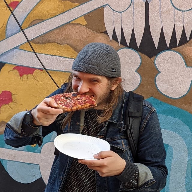 Photo of Brett eating a slice of pizza