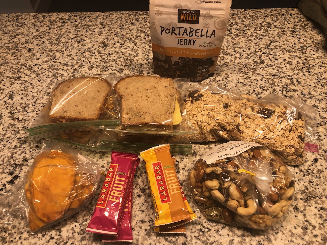 Photo of sandwiches, mangos, bars, trail mix, and oatmeal