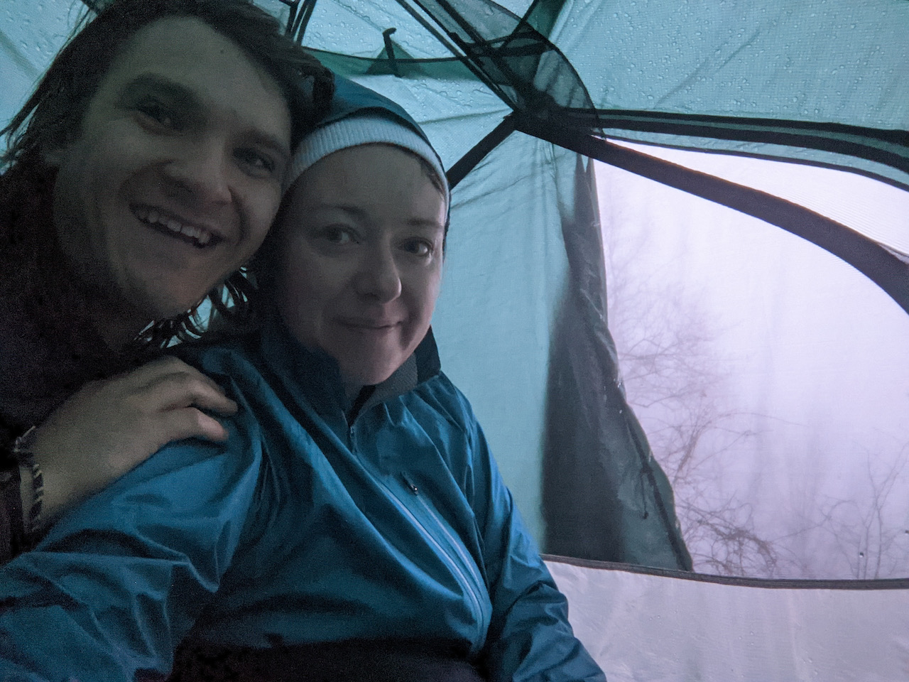 Selfie photo of Brett and Becky in the tent with the door open showing the fog